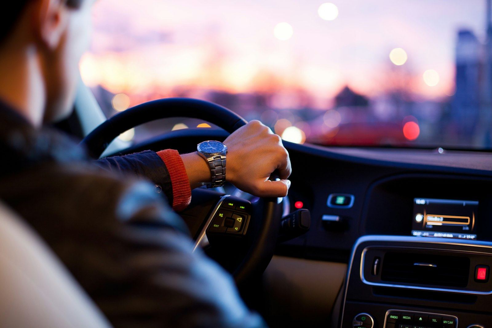 Learner driver's hands on the steering wheel at dusk