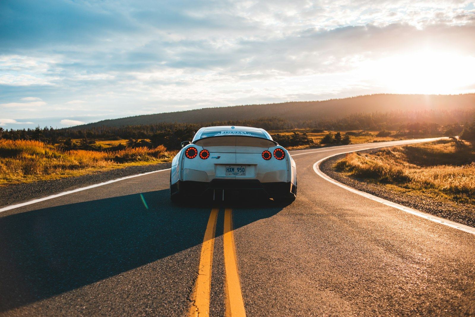 A car on a long open motorway at sunset