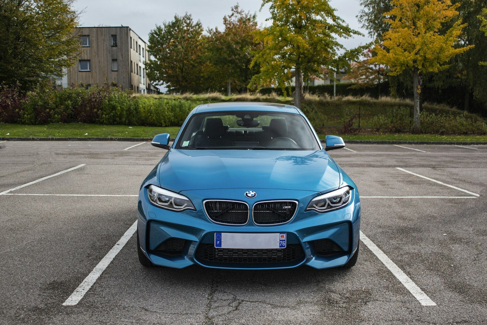 A car neatly parked within the lines of a parking bay